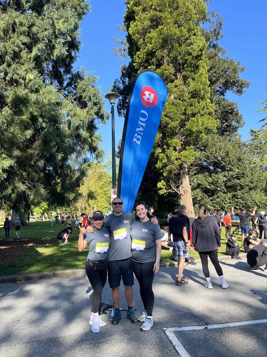 Kerr Design Build running team pose for a photo in front of a banner